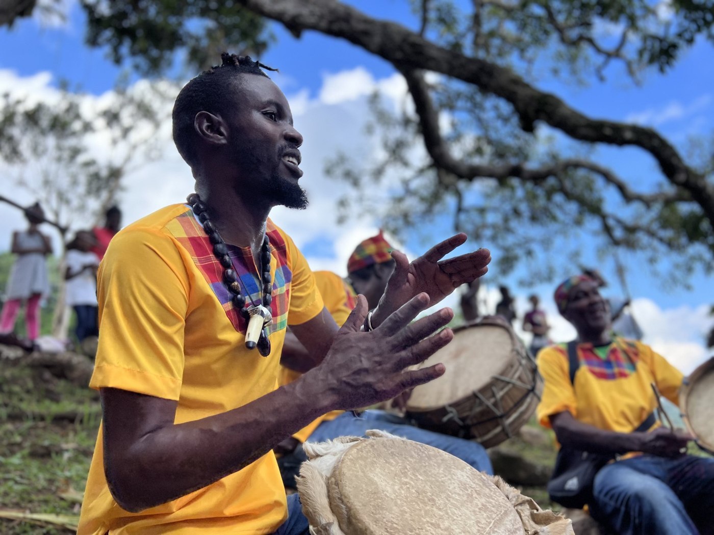 Drummers sharing music beneath the trees in Accompong